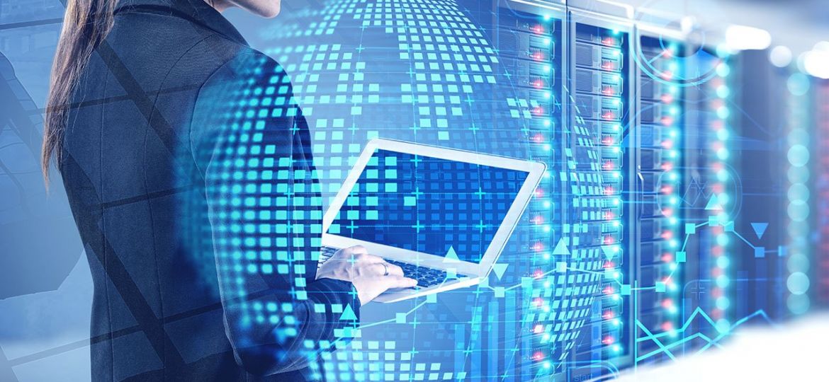 Beautiful,Young,Engineer,With,Laptop,Working,In,Blurry,Data,Center