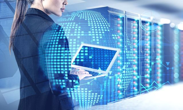 Beautiful,Young,Engineer,With,Laptop,Working,In,Blurry,Data,Center